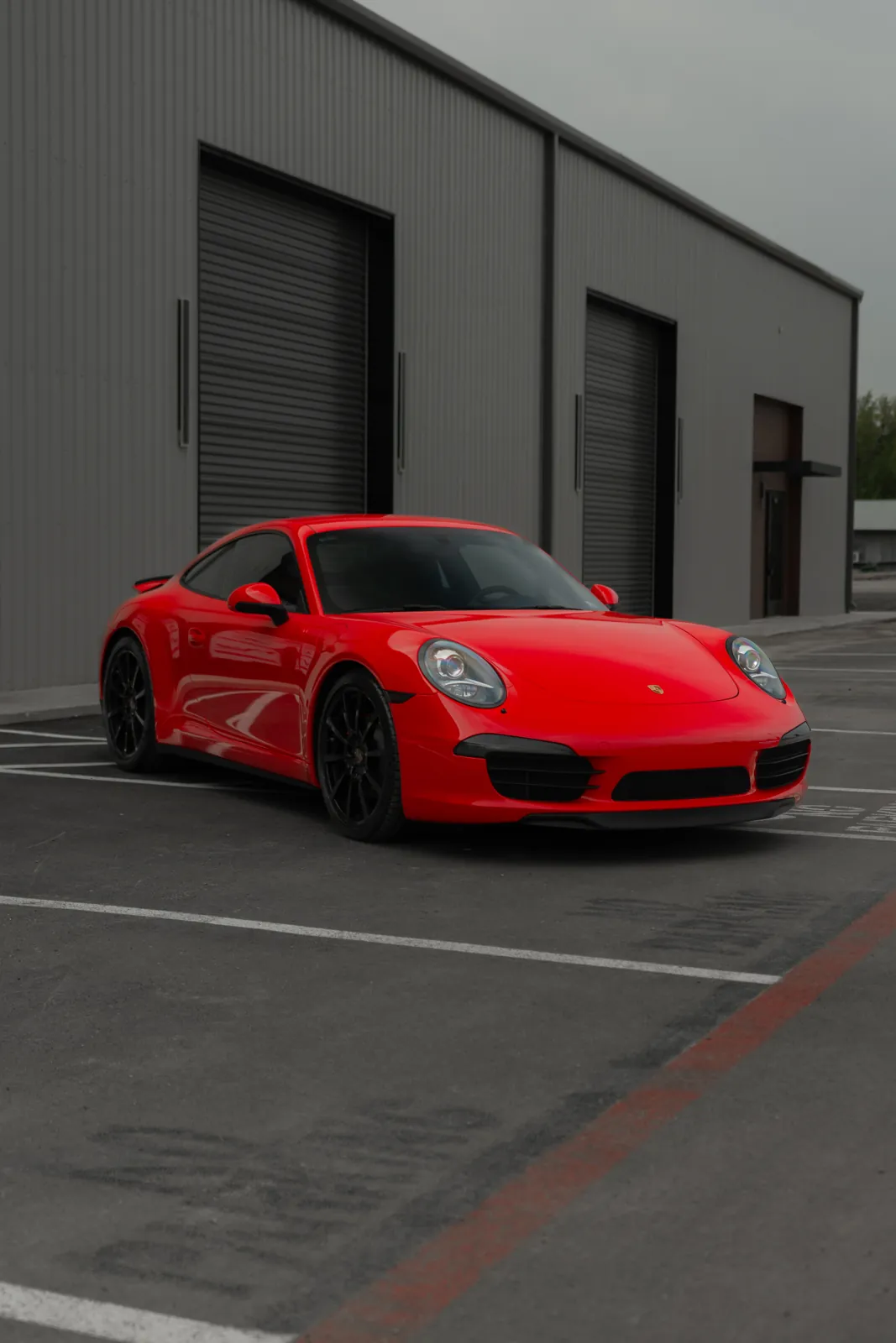 Red-wrapped Porsche 911 parked outside the Resendiz Restyling bays