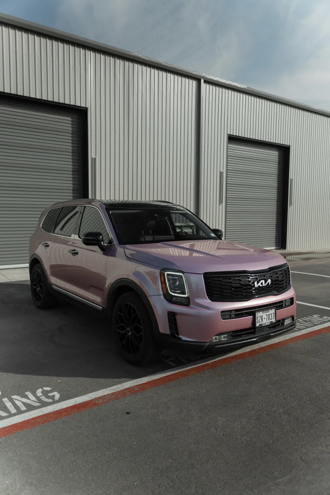 Kia Telluride in a satin rose-gold color-change wrap outside the Resendiz Restyling bays