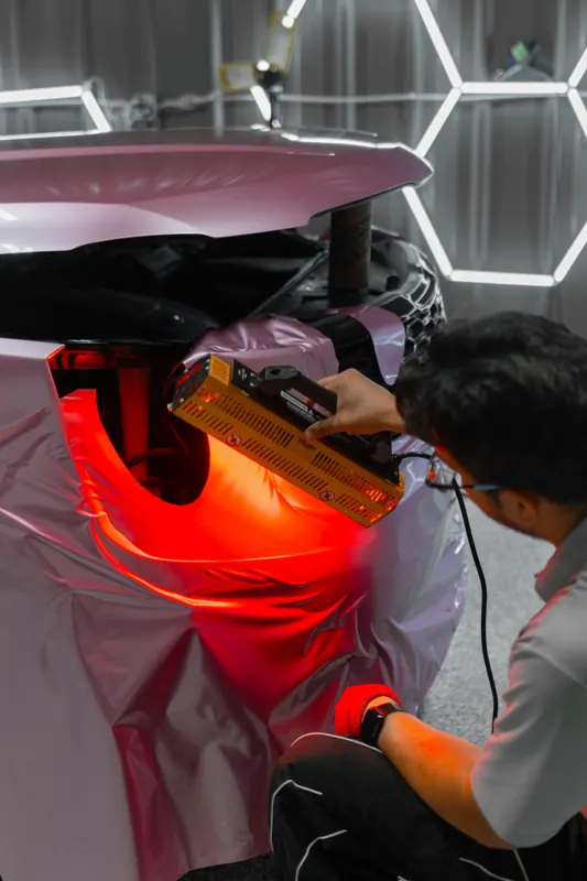 Installer heat-forming rose-gold film around the Telluride taillight